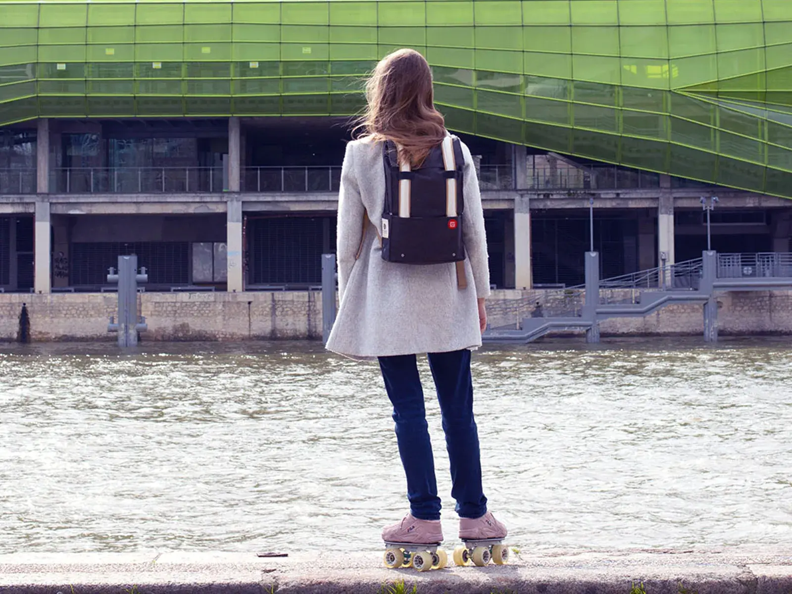 a woman using a roller skate pink to transport in the city 