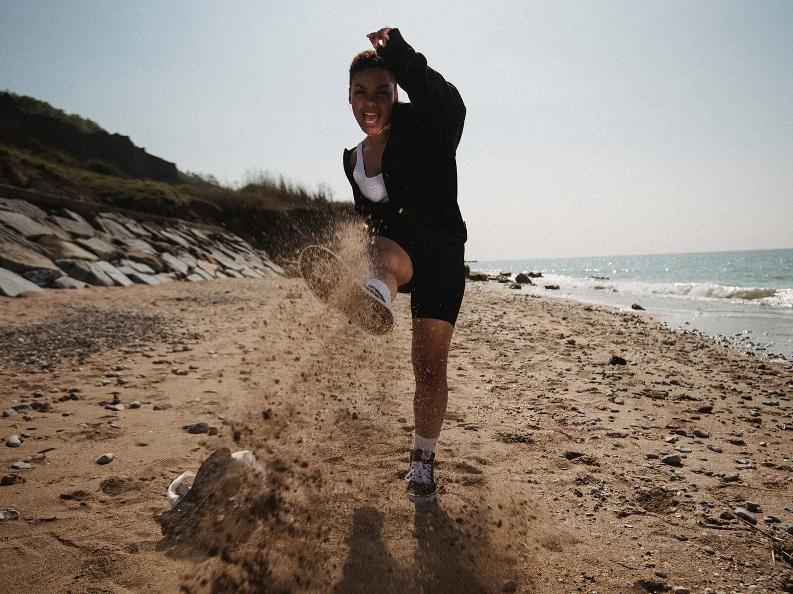 a woman playing beside the beach with her vans
