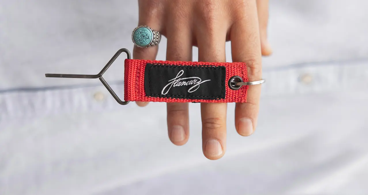 a hand holding Flaneurz clip-off red key 
