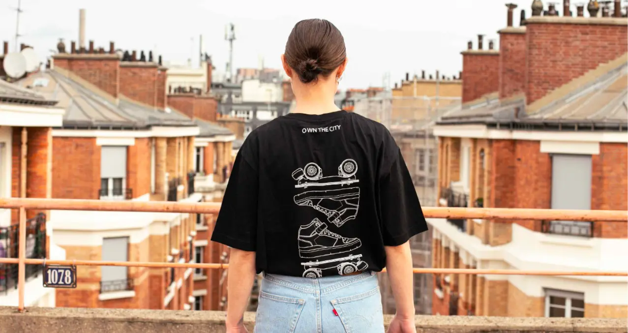a girl wearing a tshirt flaneurz black watching the city