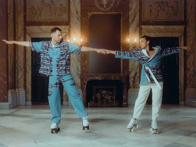 A man and a woman roller skating in a luxurious indoor setting with marble walls and an ornate fireplace. Part 2
