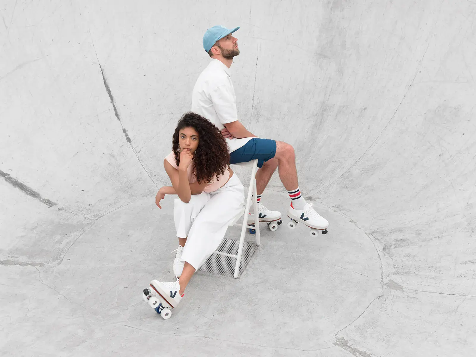 a man and a woman sitting and wearing their roller skates