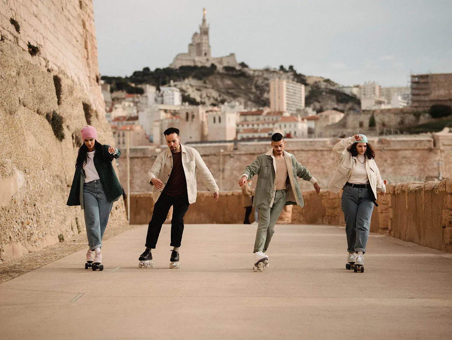 a group of people of 2 women and 2 men skating in the city