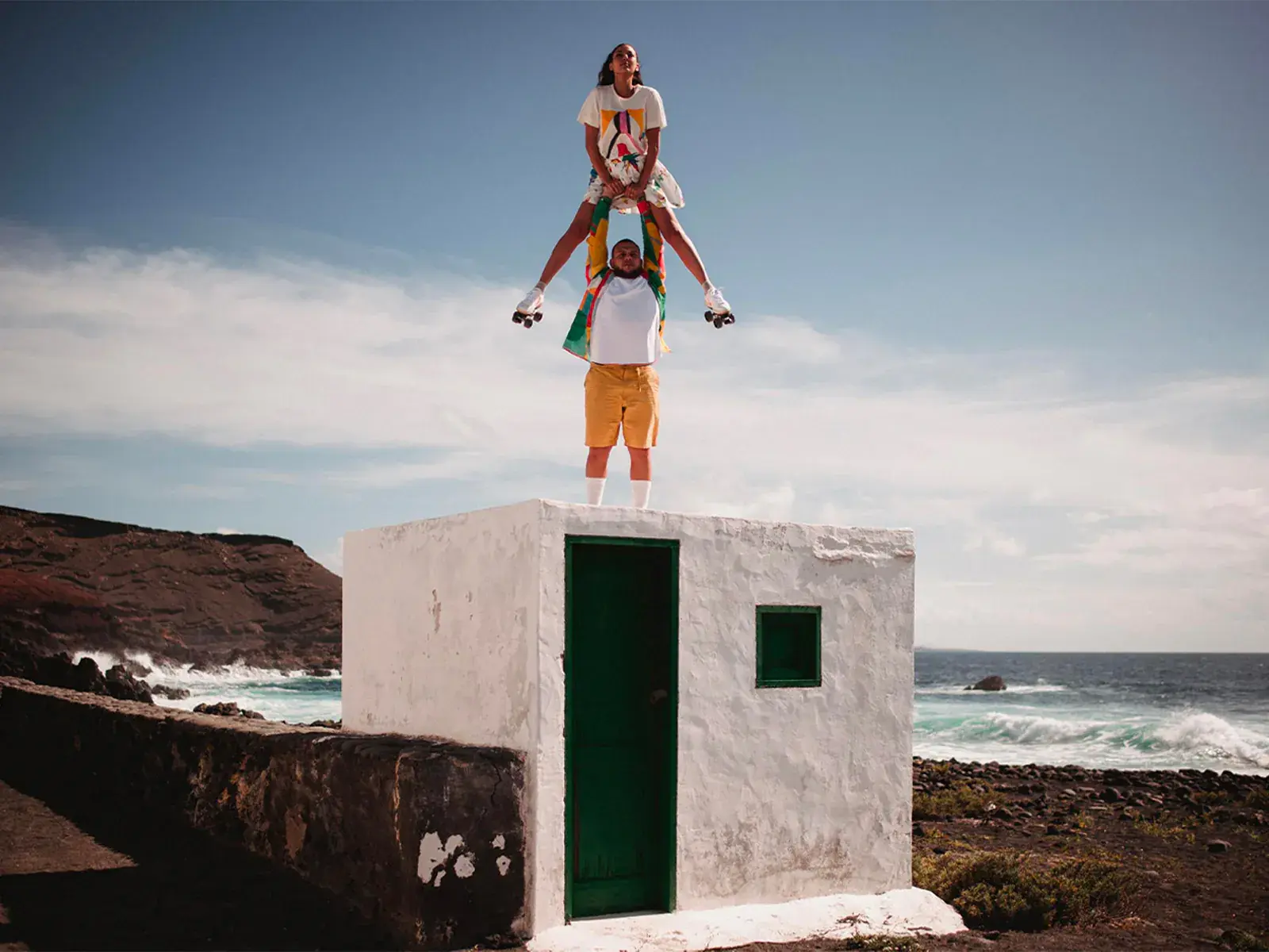 a man and a woman skating with ocean in the background