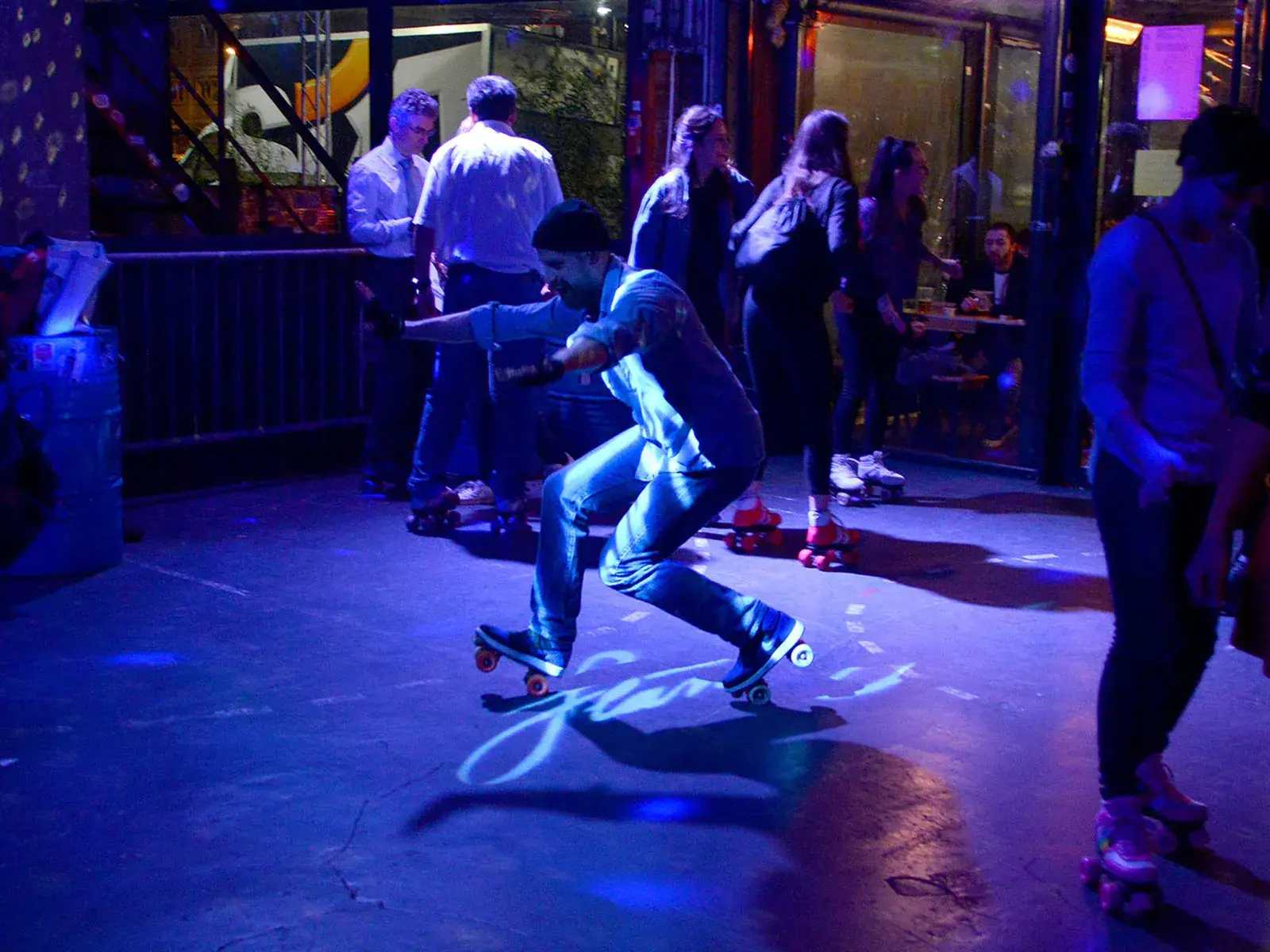 a man skating inside a club and enjoying his time 